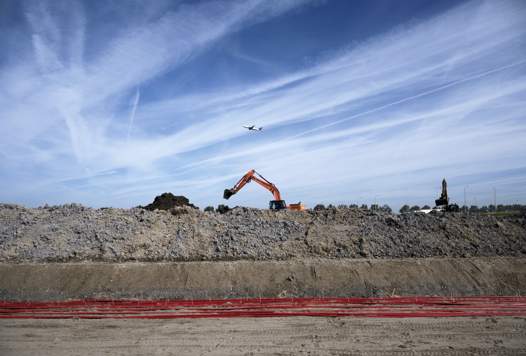 Graafmachines werken aan grondverzet voor nieuwe kabelverbindingen.