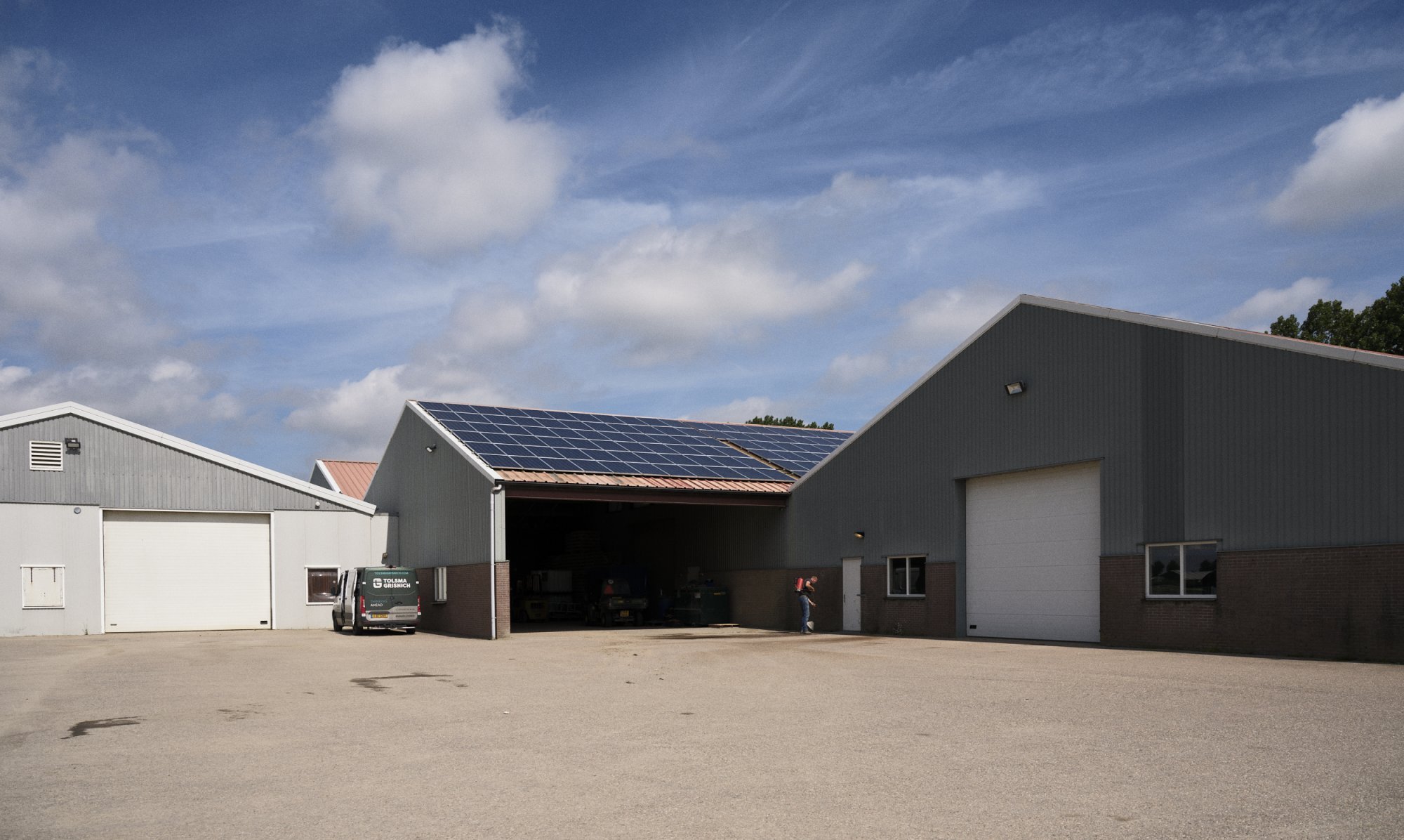 Agrarische schuur met zonnepanelen op het dak op een boerenerf.